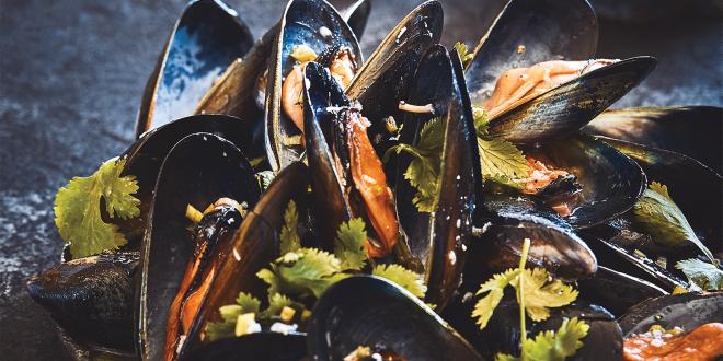 Grilled mussels served on a dark platter