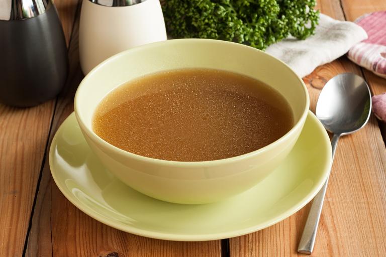A hot bowl of bone broth prepared from beef marrow